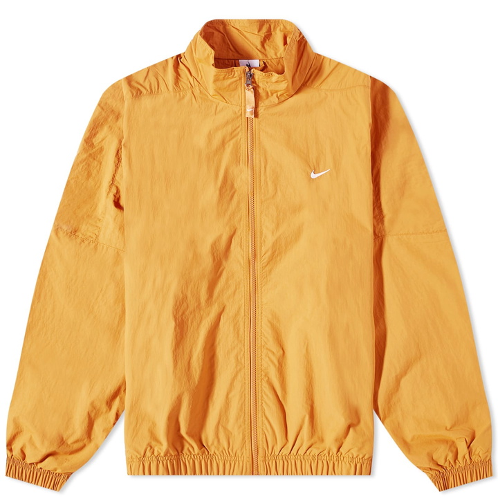 Photo: Nike Men's Solo Swoosh Woven Track Jacket in Desert Ochre/White