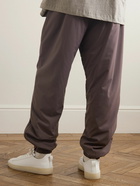 FEAR OF GOD ESSENTIALS - Tapered Logo-Appliquéd Padded Shell Drawstring Trousers - Purple