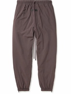 FEAR OF GOD ESSENTIALS - Tapered Logo-Appliquéd Padded Shell Drawstring Trousers - Purple