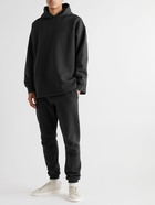 FEAR OF GOD ESSENTIALS - Tapered Logo-Flocked Cotton-Blend Jersey Sweatpants - Black