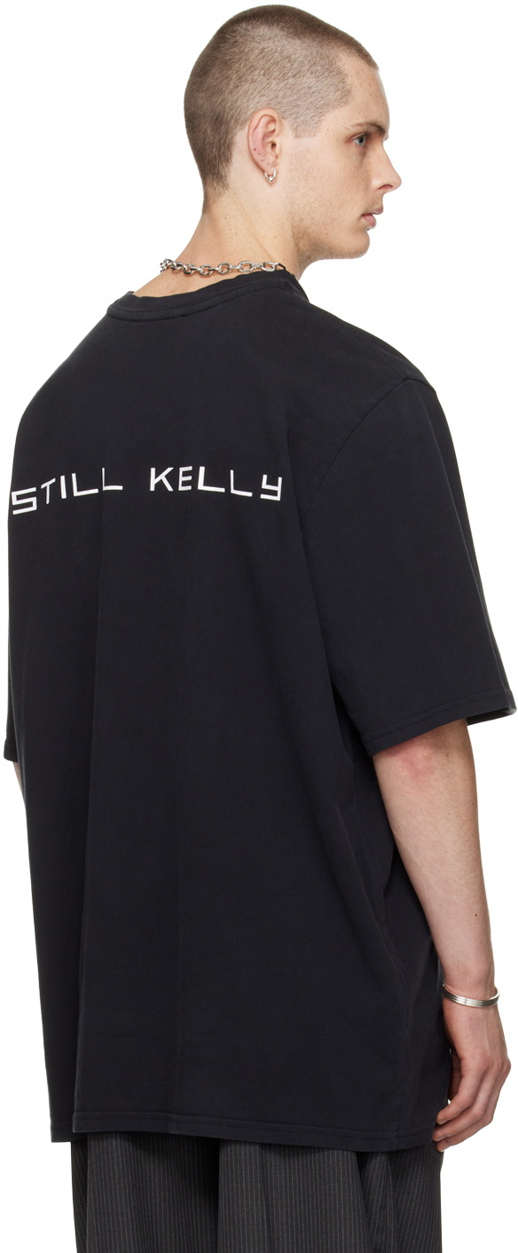 【関税込み】Still Kelly ブラック Crewneck Baby Face Tシャツ Still Kelly Black Crewneck Baby Face T-Shirt