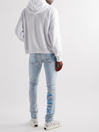 AMIRI - Skinny-Fit Logo-Print Distressed Jeans - Blue