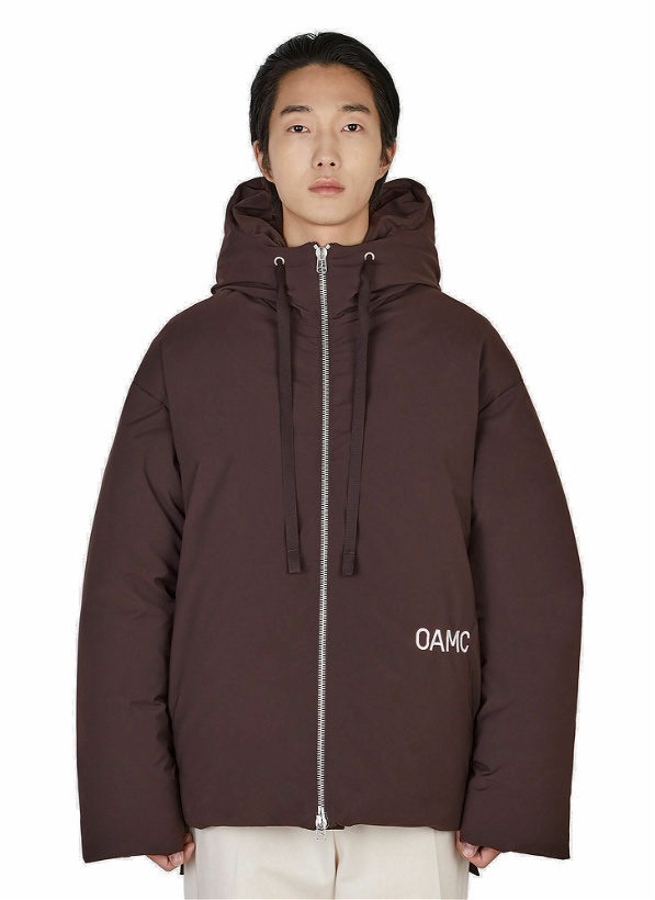 Photo: Peacemaker Hooded Puffer Jacket in Brown
