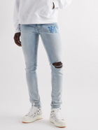 AMIRI - Skinny-Fit Logo-Print Distressed Jeans - Blue