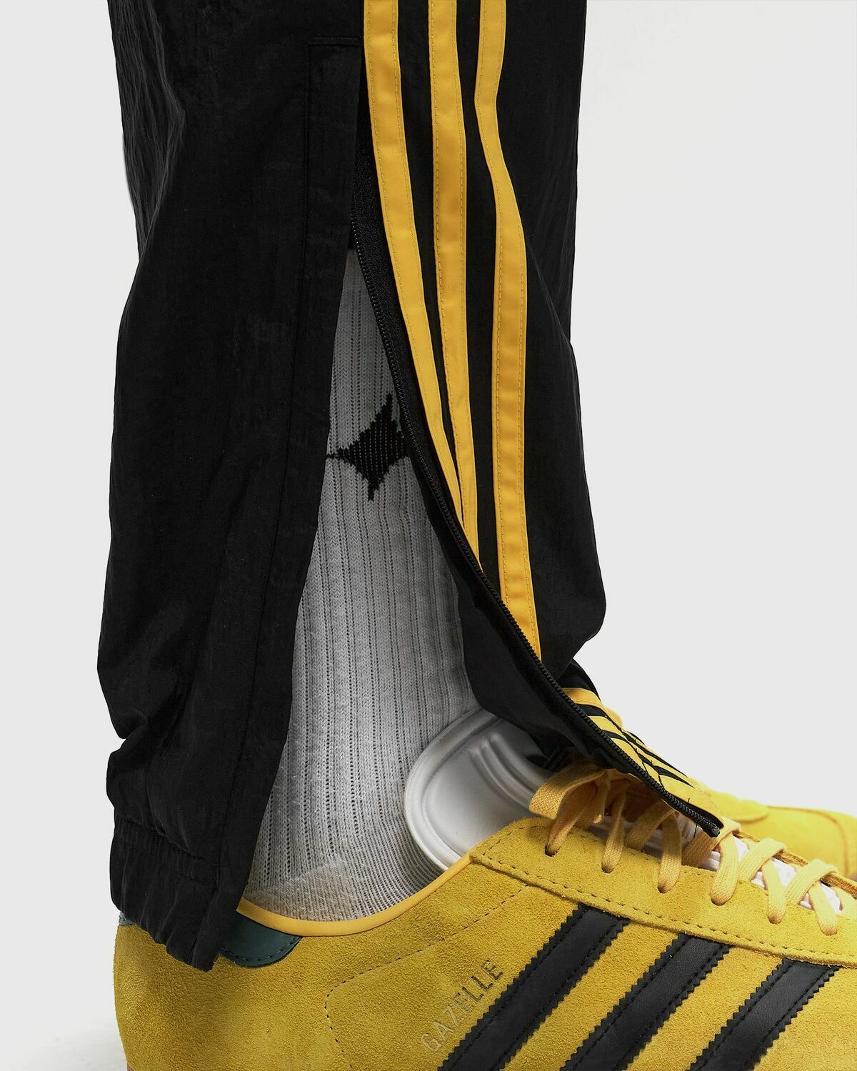 black adidas pants with gold stripes