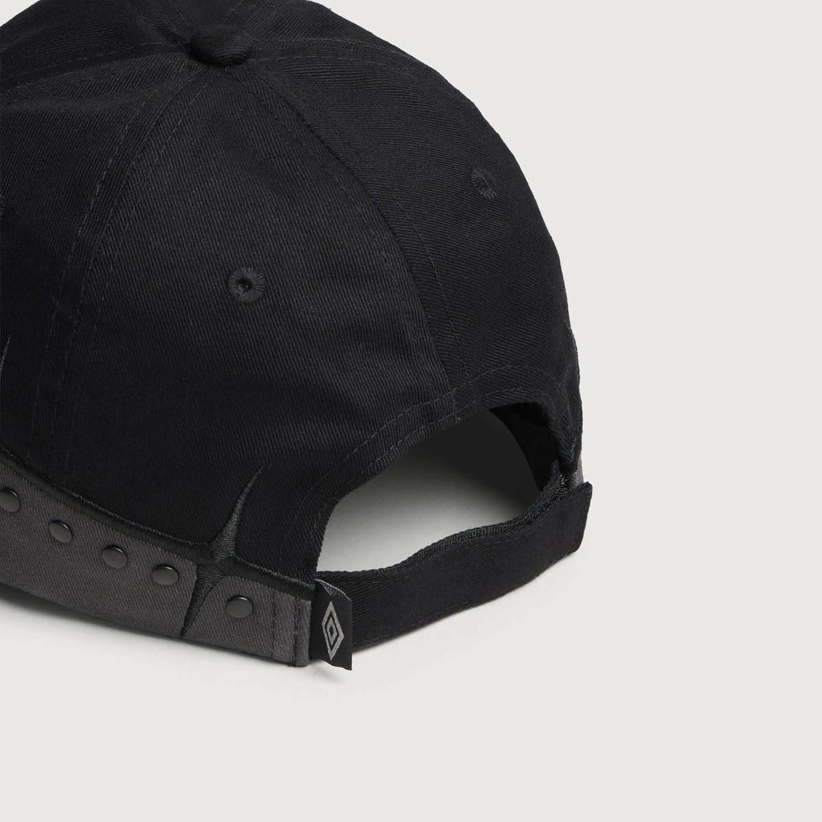 Umbro by Slam Jam Men's Spikes Stud Cap in Black